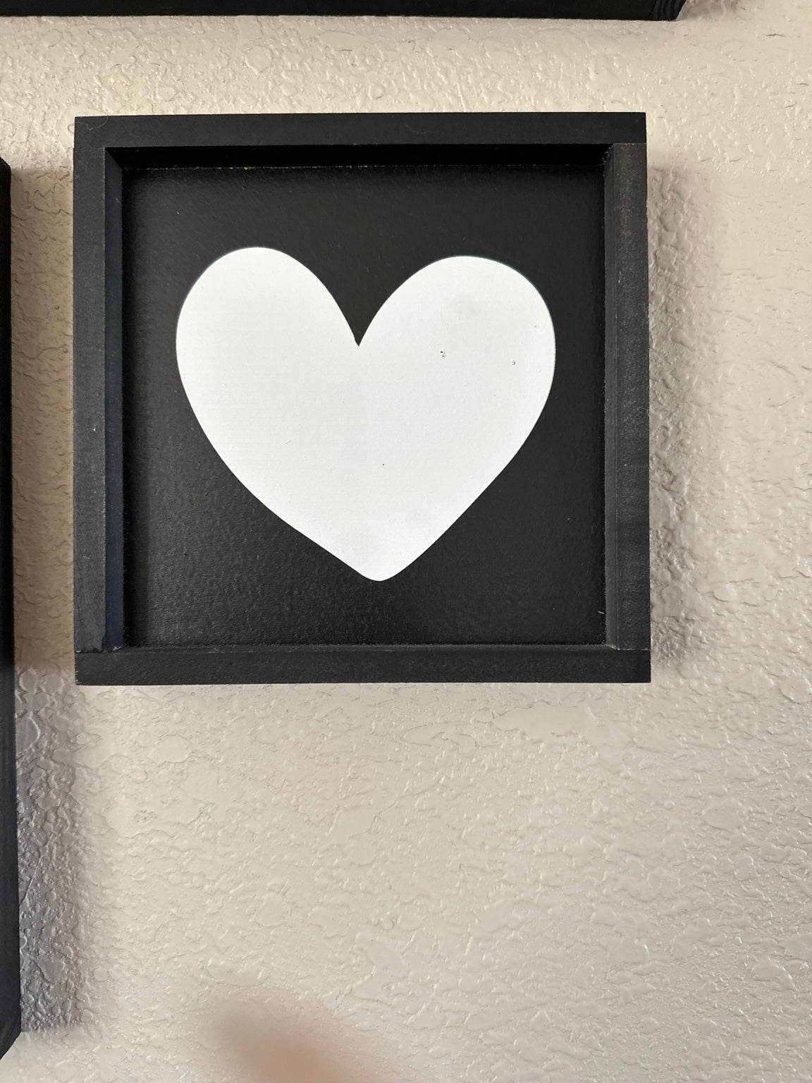 Black framed Valentine heart sign with black background and white heart