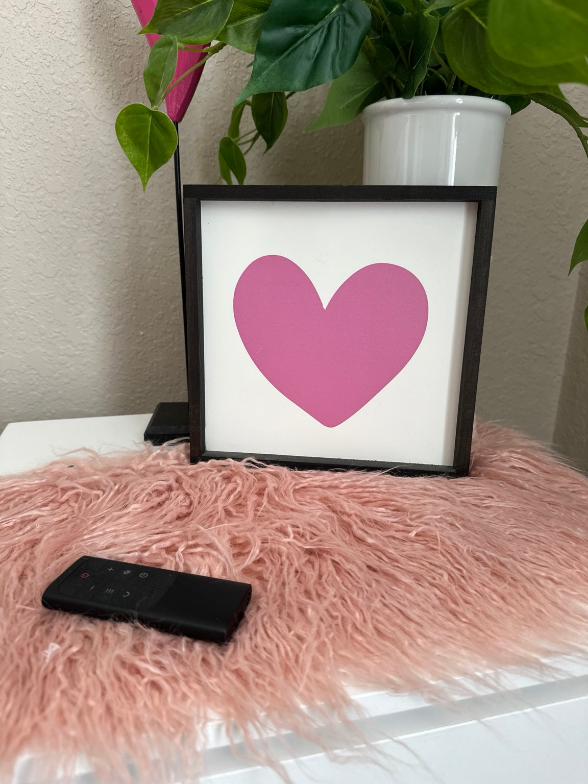 Black framed Valentine heart sign with white background and pink heart