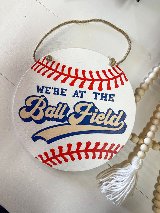 We're at the Ball field Round wood sign Baseball season welcome door hanger